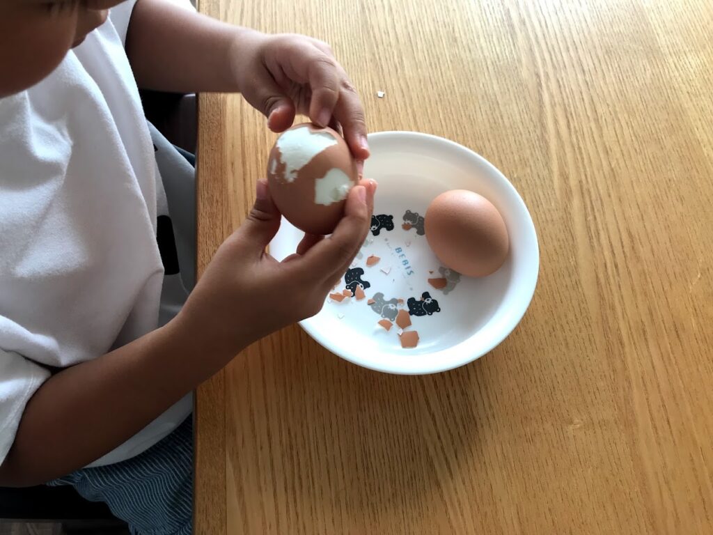 卵の殻をむく子ども